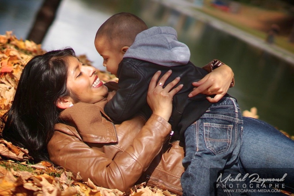 maman latino joue dans les feuille avec enfant