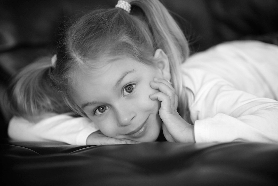 petite fille ua grand yeu sur fauteuil