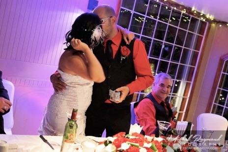 Couple mariés s'embrasse à la table d'honneur