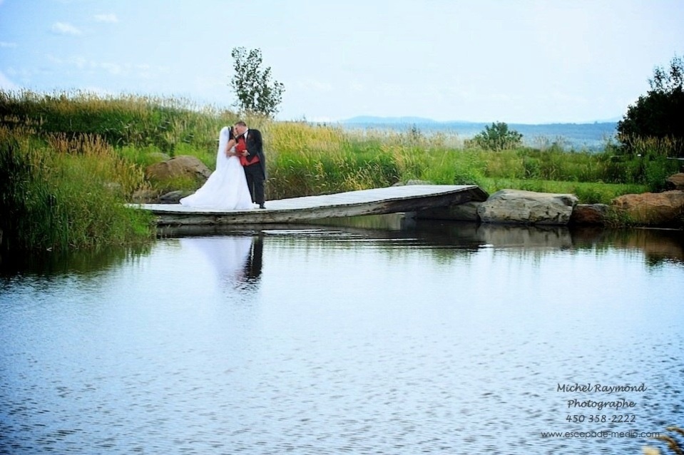 les mariés s'embrasse près du lac du Domaine Deguire